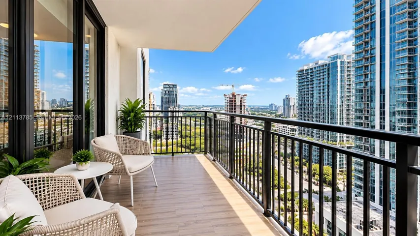 Covered balcony featuring wood-finish flooring and black metal railing