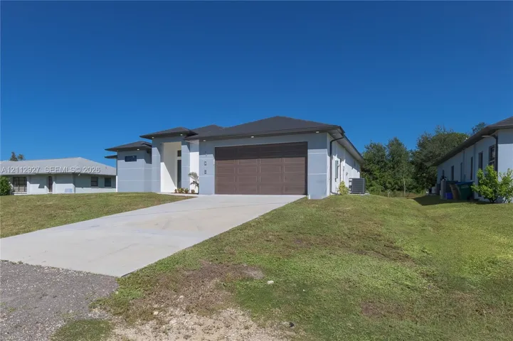 Modern single-story exterior featuring a light-colored stucco facade, a multi-section dark brown garage door, and a multi-dimensional shingle roof