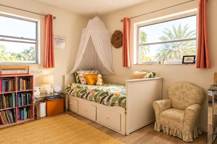 Neutral-toned interior featuring wood-finish flooring, dual windows with metallic hardware, and natural light exposure
