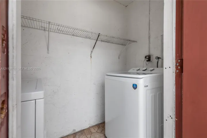 Laundry space featuring wall-mounted wire shelving and dedicated water hookups