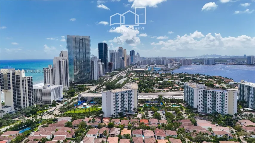 Aerial perspective of a coastal urban landscape featuring ocean and bay shorelines, high-rise buildings, and dense residential development