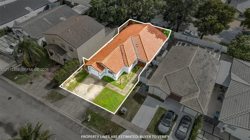 Single-story residence featuring a terracotta-tiled roof, white stucco exterior, attached garage, and a fenced backyard