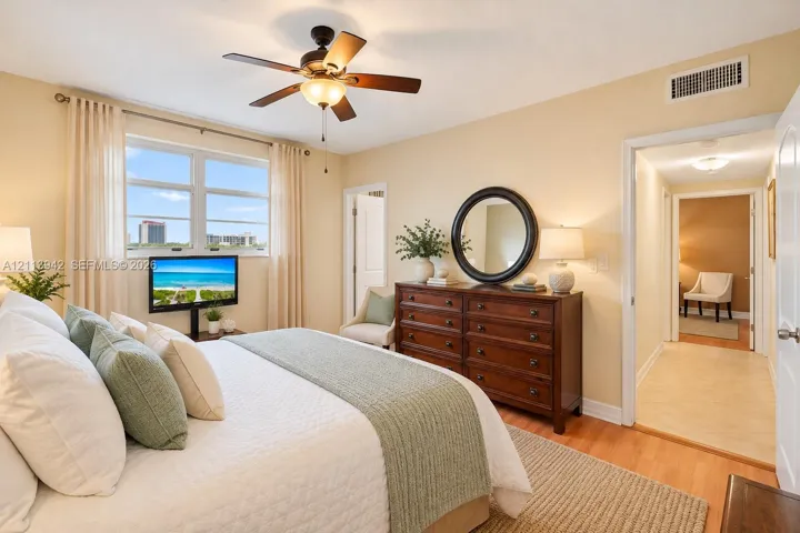 Bedroom featuring wood-finish flooring, a ceiling fan with integrated lighting, and dual-pane windows