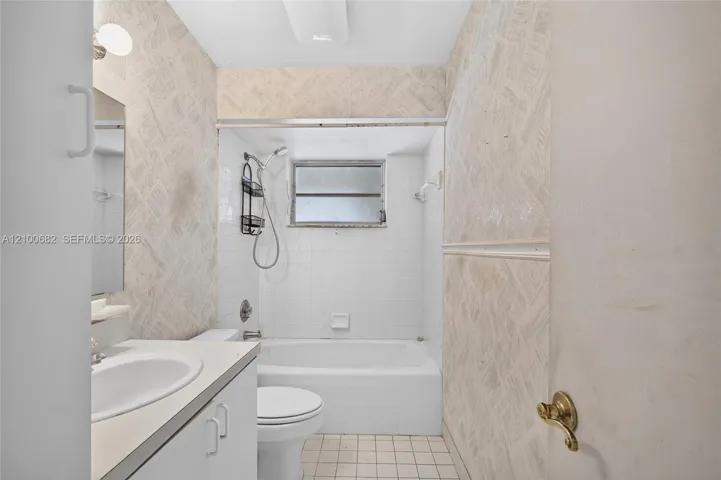Hall bathroom featuring a vanity with a white countertop and oval sink, a combined tub and shower enclosure *
