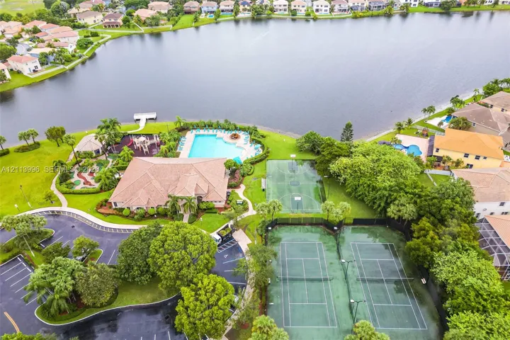 Waterfront recreational complex featuring an outdoor swimming pool, two tennis courts, a basketball court, and a miniature golf course