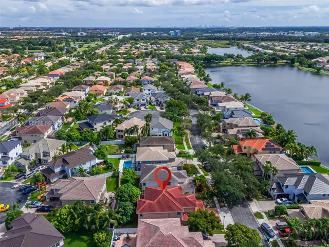 Aerial perspective featuring a multi-gabled residence with a terracotta tile roof and an attached swimming pool
