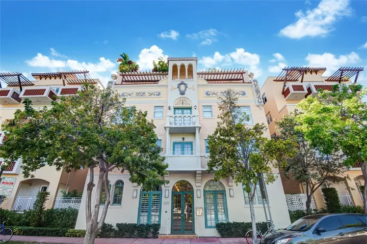 Mediterranean-style exterior featuring decorative molding, a prominent center balcony, rooftop pergola structures, and arched entryway
