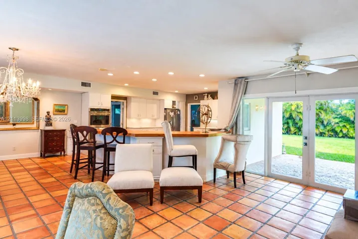Kitchen featuring white cabinetry, wood-surface peninsula, built-in double oven, recessed lighting, and tile flooring