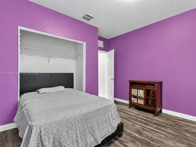 Wood-finish flooring and a walk-in closet featuring wire shelving