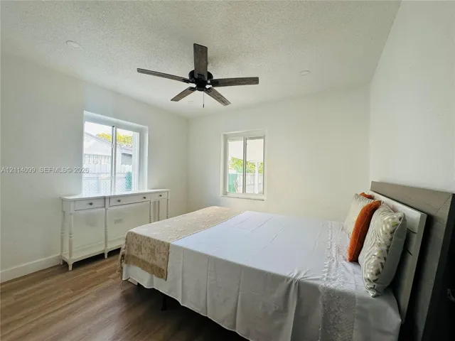 Wood-finish flooring, recessed lighting, multi-blade ceiling fan, and dual single-hung windows