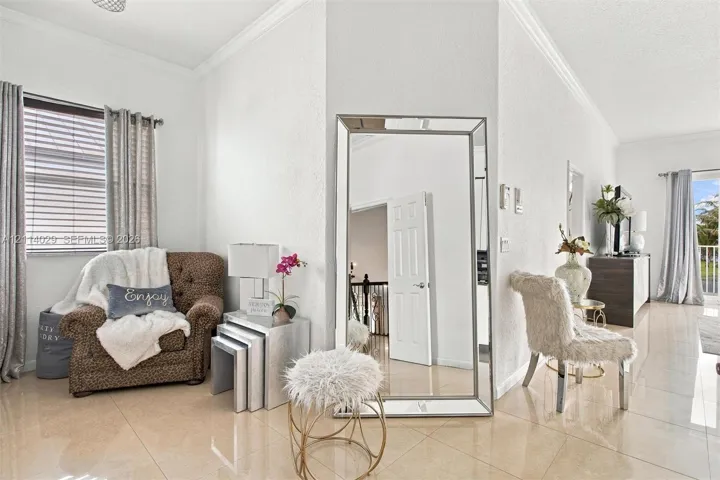 Large format tile flooring, crown molding, and horizontal slat window blinds
