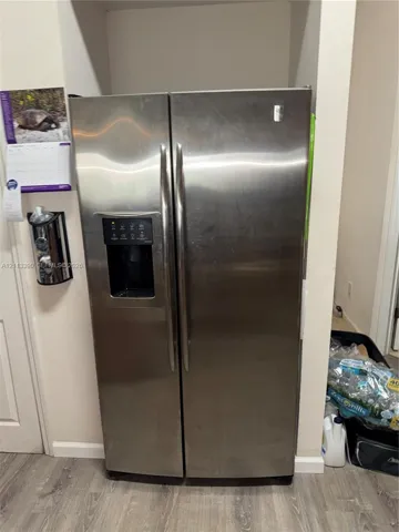 Stainless steel side-by-side refrigerator featuring an integrated water and ice dispenser