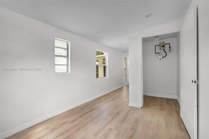 Neutral interior featuring wood-finish flooring, recessed lighting, and multiple windows