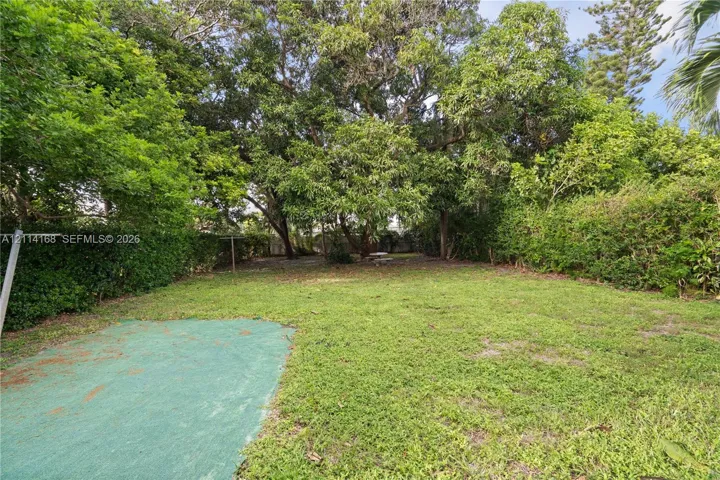 Expansive backyard featuring a lawn, mature trees, and perimeter shrubbery-Room for a pool