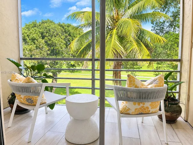 Screened-in balcony featuring wood-finish tile flooring overlooking the golf course