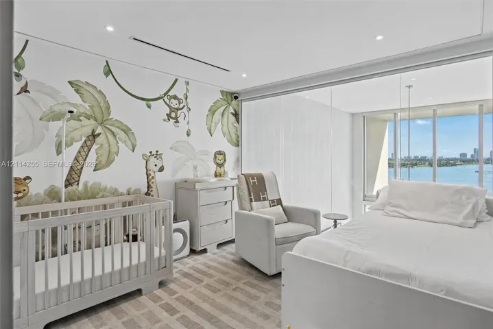Floor-to-ceiling windows with water backdrop, recessed lighting, and wall-to-wall carpeting