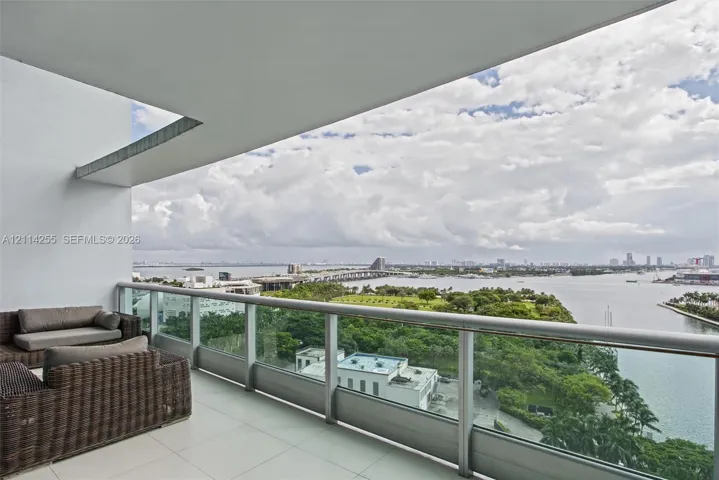 Covered balcony featuring large-format tile flooring and a glass-panel railing
