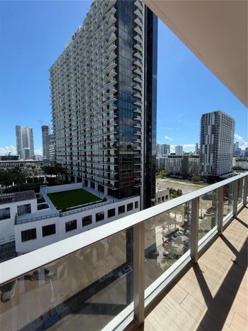 Private balcony featuring wood-finish tile flooring and a glass panel railing