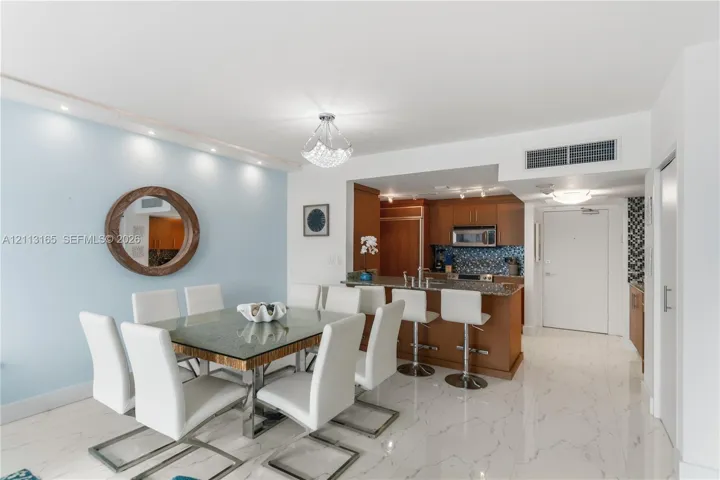 Kitchen featuring wood cabinetry, stone countertops, and integrated appliances with a breakfast bar