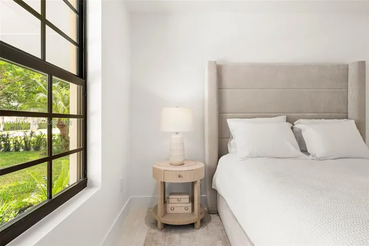 Large multi-pane window with dark metal framing and light-toned wood-finish flooring