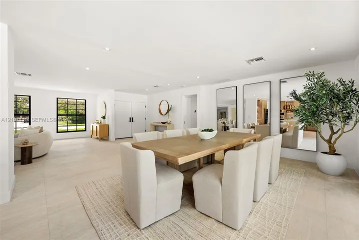 Open-concept room featuring light-toned tile flooring, recessed ceiling lighting, and large, black-framed windows