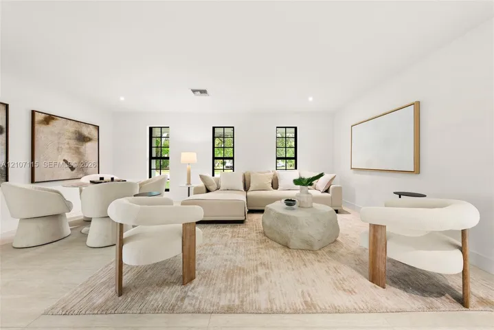 Living area featuring light-toned tile flooring, recessed lighting, and three tall windows with black frames