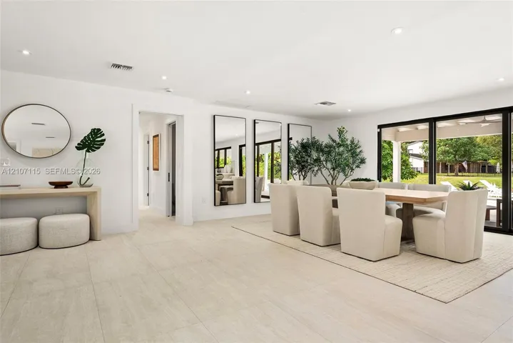 Large-format tile flooring, recessed ceiling lighting, and expansive glass sliding doors