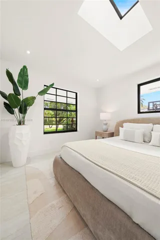 Skylight, multi-pane black-framed windows, and light-toned flooring