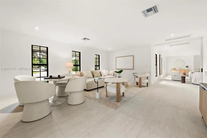 Open-concept interior featuring large-format tile flooring, recessed lighting, and black-trimmed multi-pane windows