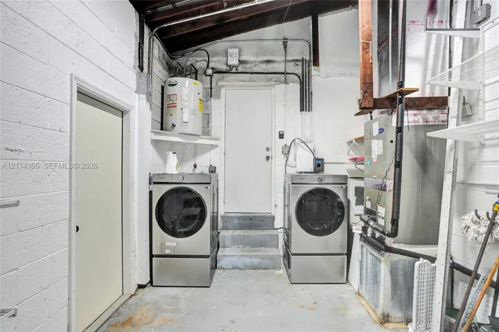 Utility area featuring a water heater, central HVAC unit, concrete walls, and concrete flooring