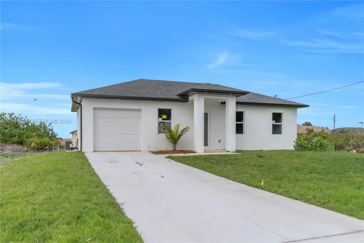 Single-story residence featuring a smooth stucco exterior, a concrete driveway, an attached garage, and a covered entryway