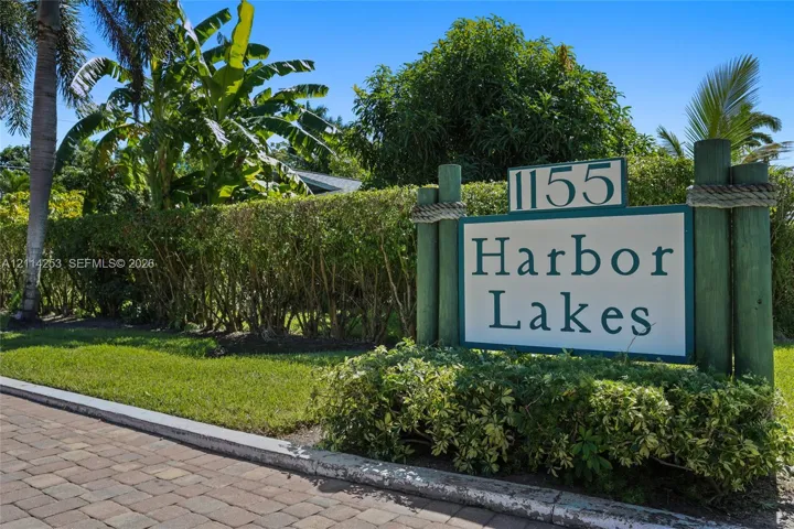 Custom signage featuring timber posts and rope detailing, complemented by landscaped hedging and paver stone hardscaping