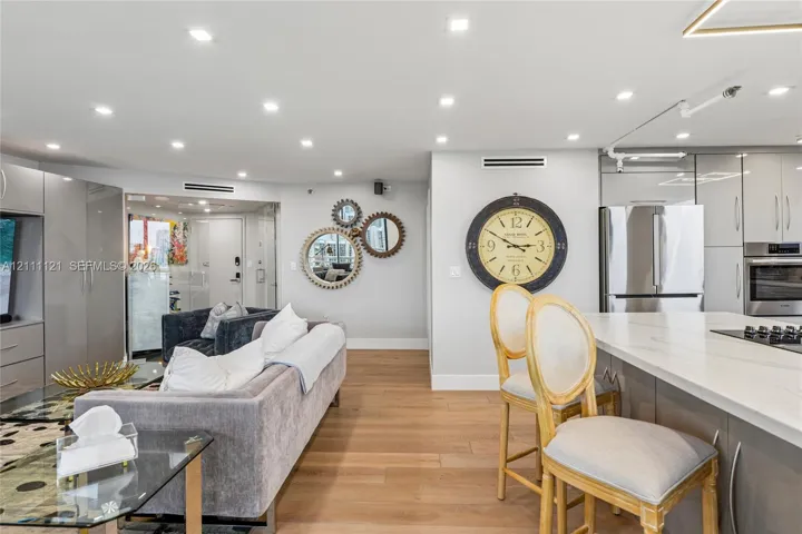 Open-concept interior featuring light wood-finish flooring, recessed lighting, and a kitchen island with a white countertop