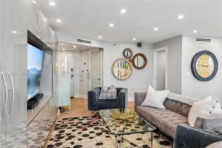 Recessed lighting, wood-finish flooring, high-gloss built-in cabinetry, and glass-paneled interior entry
