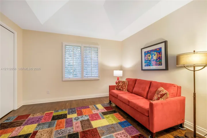 Vaulted ceiling, wood-finish flooring, and window shutters