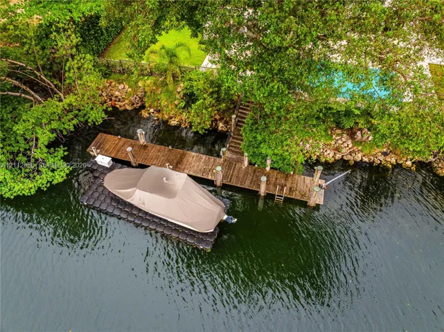 Private wooden dock featuring a fixed pier, integrated ladder, and a modular floating boat lift