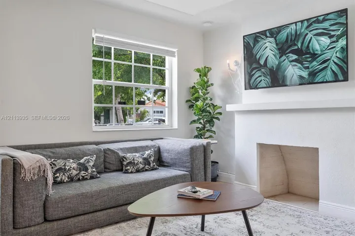 Fireplace with a minimalist mantel, grid-pattern window, and wall-mounted lighting fixture