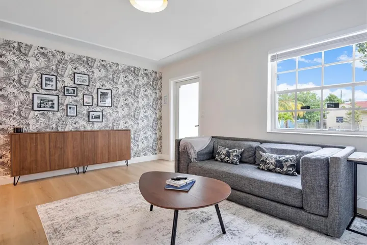 Interior space featuring wood-finish flooring, a decorative patterned accent wall, and a multi-pane window