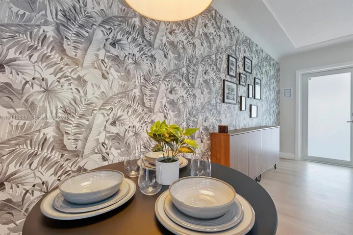 Interior space featuring palm-leaf pattern wallpaper, light-toned wood-finish flooring, and a recessed ceiling fixture