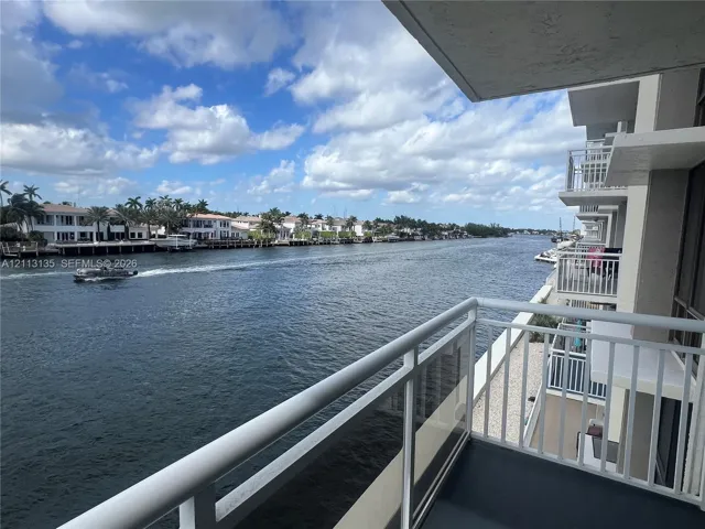 Covered private balcony featuring glass and metal railings with a direct waterfront exposure