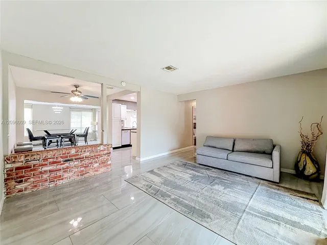 Large-format tile flooring, exposed brick half-wall partition, and neutral interior wall paint