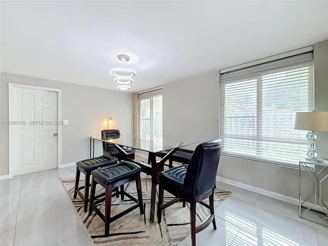 Multi-tiered circular pendant light, large-format tile flooring, and oversized windows with horizontal blinds
