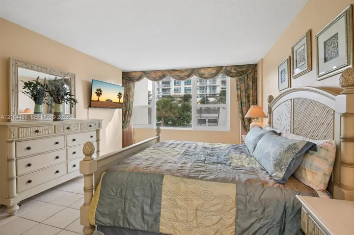 Bedroom featuring large windows, neutral wall paint, and ceramic tile flooring