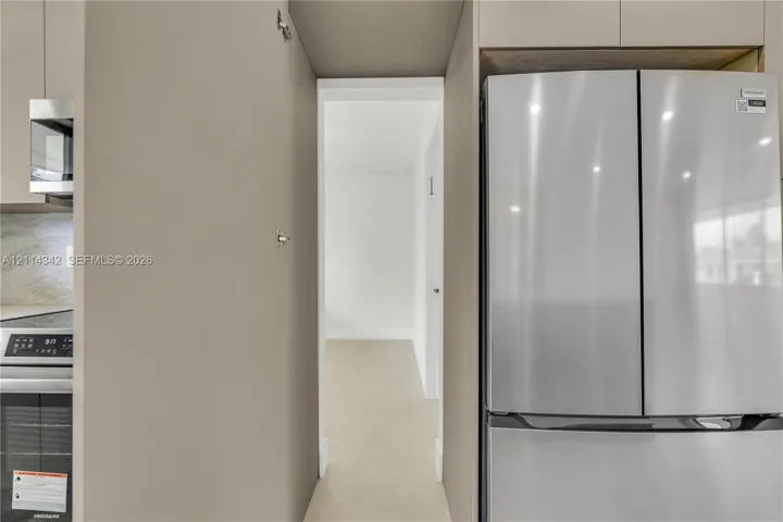 Kitchen featuring stainless steel refrigerator, integrated cabinetry, and built-in microwave