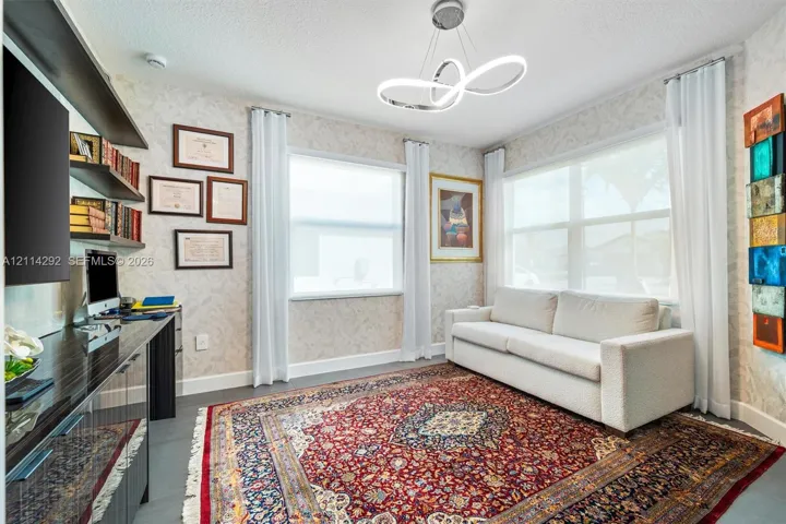 Room featuring patterned wallcoverings, multi-tiered contemporary circular light fixture, built-in dark finish cabinetry, and dual windows