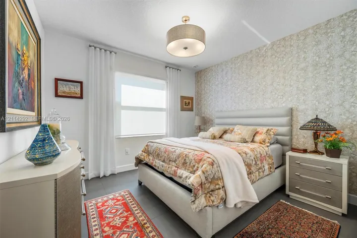 Textured wallpaper accent wall, large-format tile flooring, and drum-style ceiling light fixture