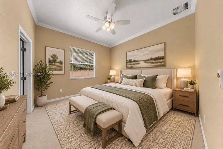 Bedroom featuring neutral wall paint, carpeted flooring, crown molding, and a white ceiling fan with integrated lighting