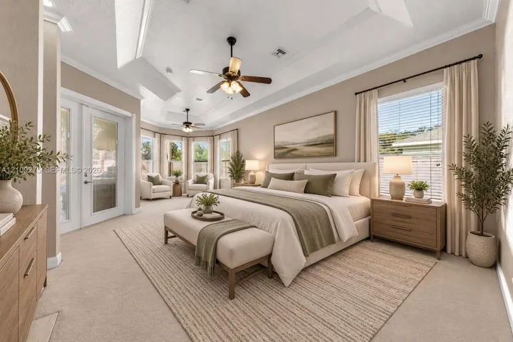 Tray ceiling, dual ceiling fans, recessed lighting, and expansive windows featuring glass door access to the exterior