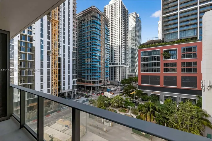 Private balcony featuring a dark metal railing and tempered glass panels