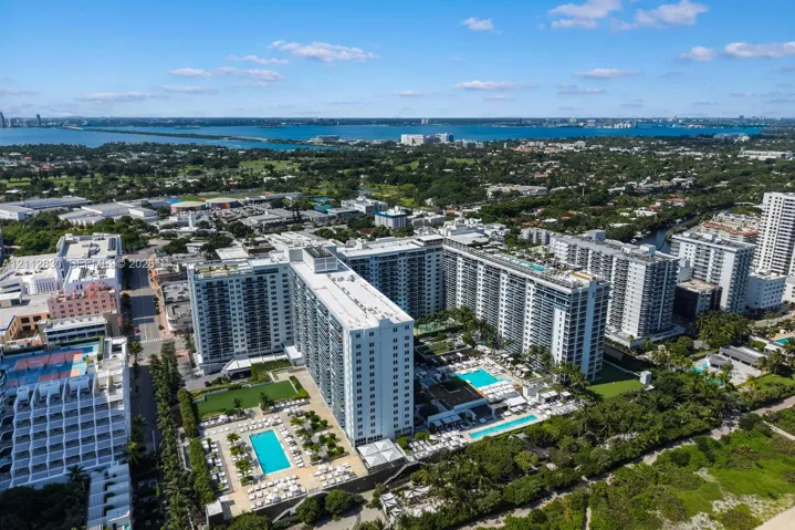 Aerial perspective featuring multiple high-rise structures, landscaped grounds, and multiple outdoor swimming​​‌​​​​‌​​‌‌​‌‌​​​‌‌​‌​‌​‌​​​‌​​ pools